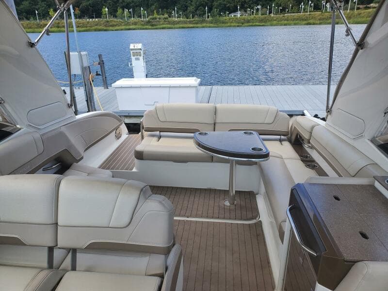 2015 Formula 330 Crossover Bowrider interior with seating and table, docked by a lake.