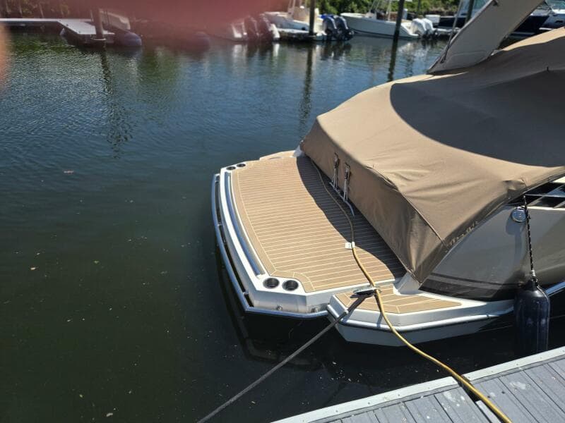 2015 Formula 330 Crossover Bowrider docked with cover, rear view.