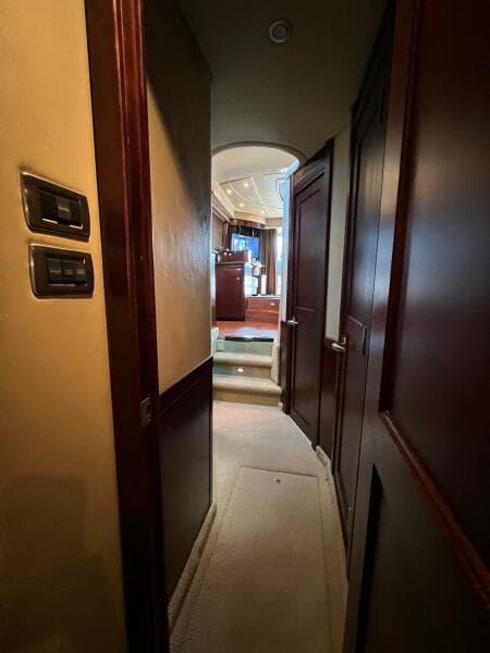 Hallway inside 2005 Sea Ray 500 Sedan Bridge yacht with wooden doors and carpeted floor.