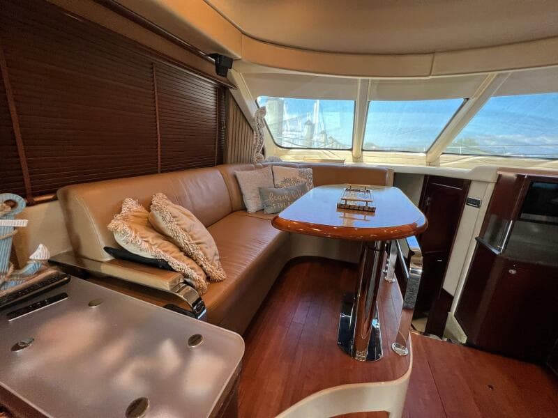 Luxurious interior of 2005 Sea Ray 500 Sedan Bridge yacht with plush seating and elegant table.