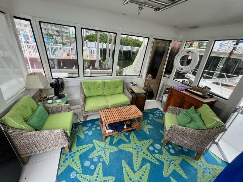 Interior of 2000 Carver 506 Motor Yacht with green seating and starfish-patterned rug.