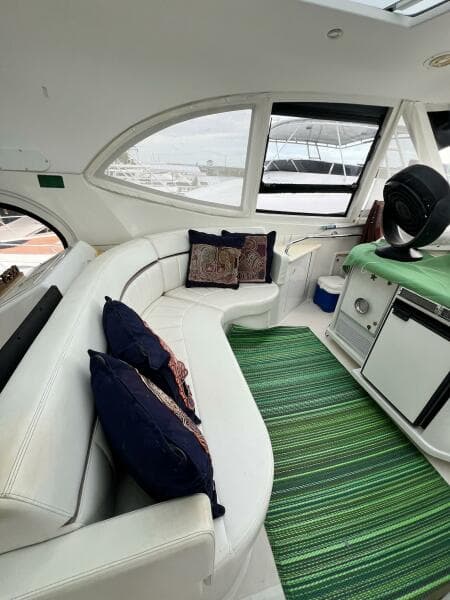 Interior of 2000 Carver 506 Motor Yacht with white seating and green rug.