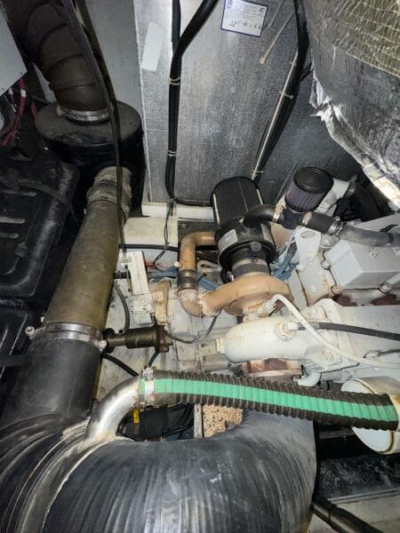 Engine room of a 2000 Carver 506 Motor Yacht, showcasing mechanical components and piping.