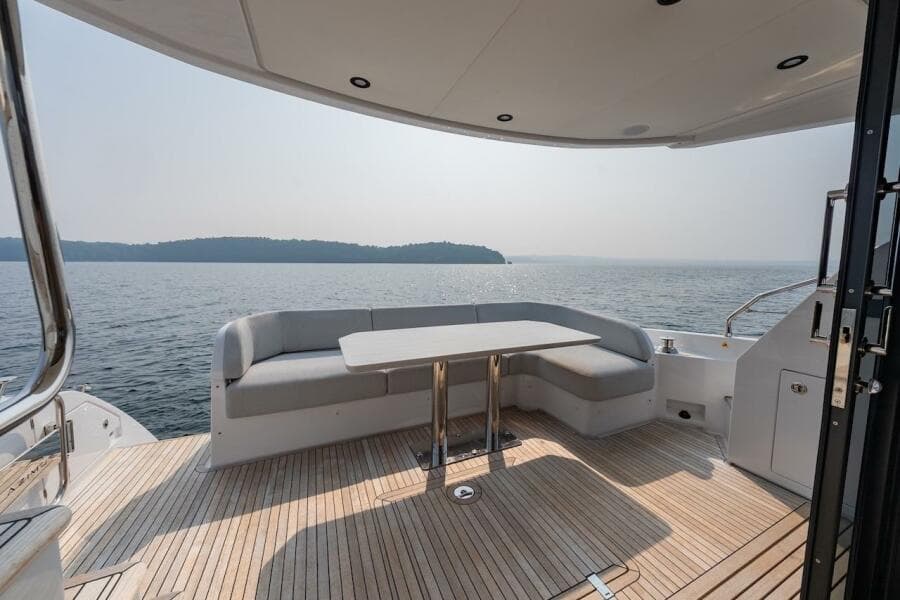 Luxury Azimut Fly 53 yacht deck with seating, overlooking serene water and distant shoreline.