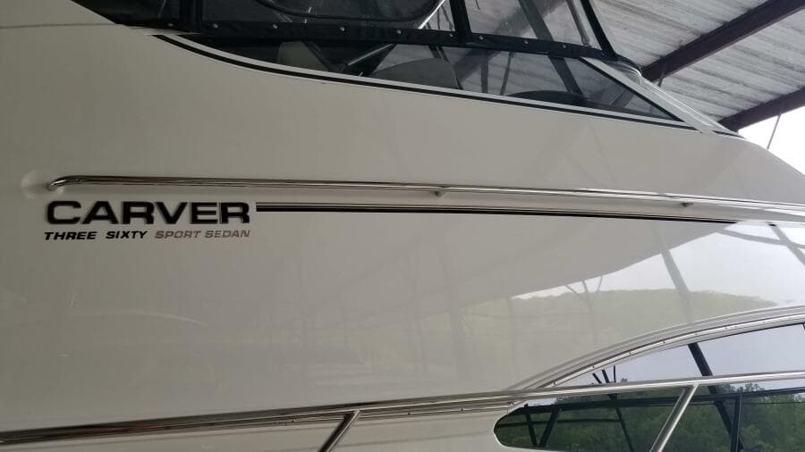 2004 Carver 360 Sport Sedan boat side view with logo under a canopy.
