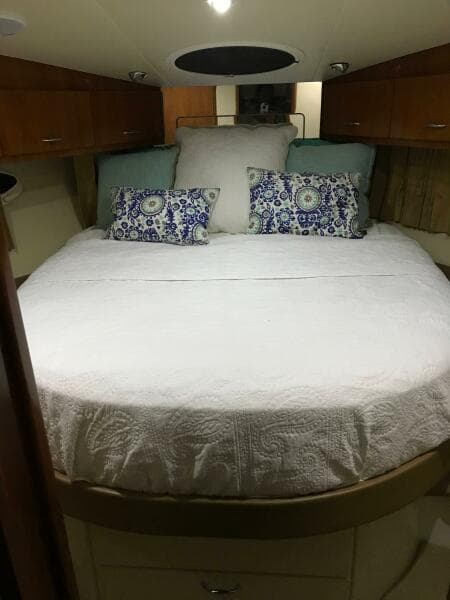 Luxurious bedroom interior of 2004 Carver 360 Sport Sedan with elegant bedding and wood cabinetry.