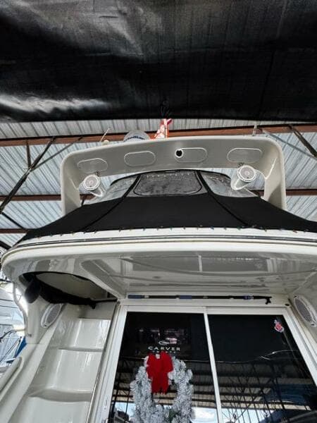 2004 Carver 360 Sport Sedan yacht under a covered dock, rear view.