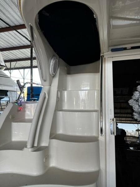2004 Carver 360 Sport Sedan yacht interior stairs under a covered dock.