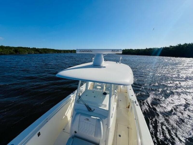 2021 Cobia 301 Center Console boat on a sunny day, cruising on open water.