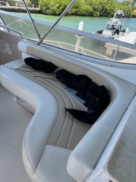 2006 Carver 43 Motor Yacht with white curved seating and scenic waterfront view.