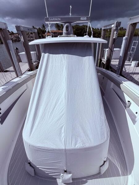 2024 Scout 400 LXF boat with covered console, docked under cloudy skies.