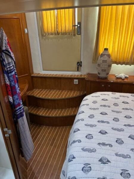 Interior of 2006 Carver 43 Motor Yacht with wooden steps and nautical-themed bedding.