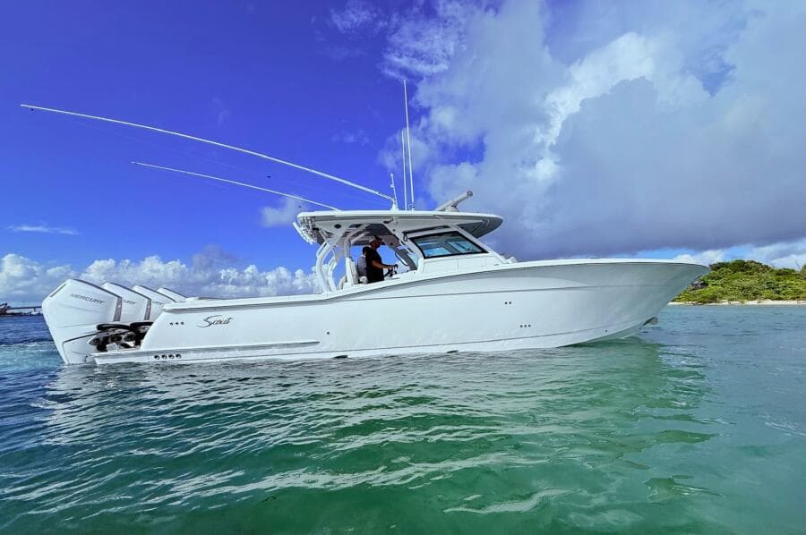 2024 Scout 400 LXF boat on clear water under a blue sky.