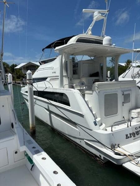 2006 Carver 43 Motor Yacht docked at marina under clear blue sky.