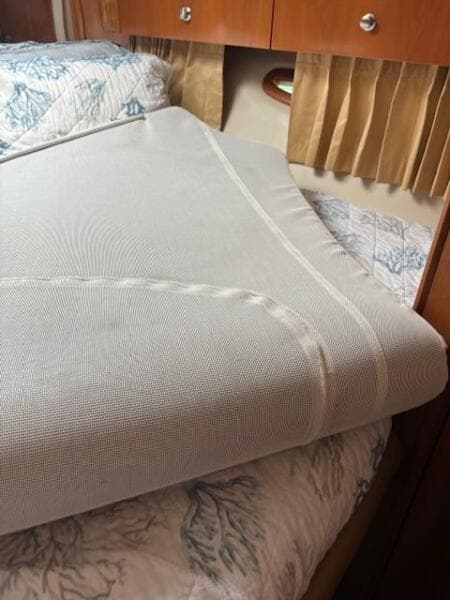 Interior of 2006 Carver 43 Motor Yacht with neatly made bed and wooden cabinetry.