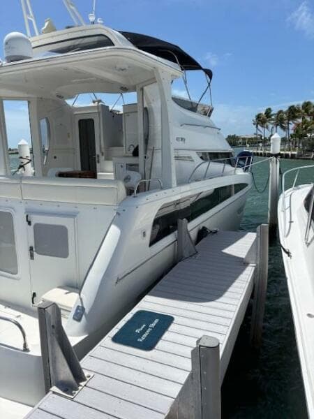 2006 Carver 43 Motor Yacht docked at marina, sunny day, clear skies, palm trees in background.