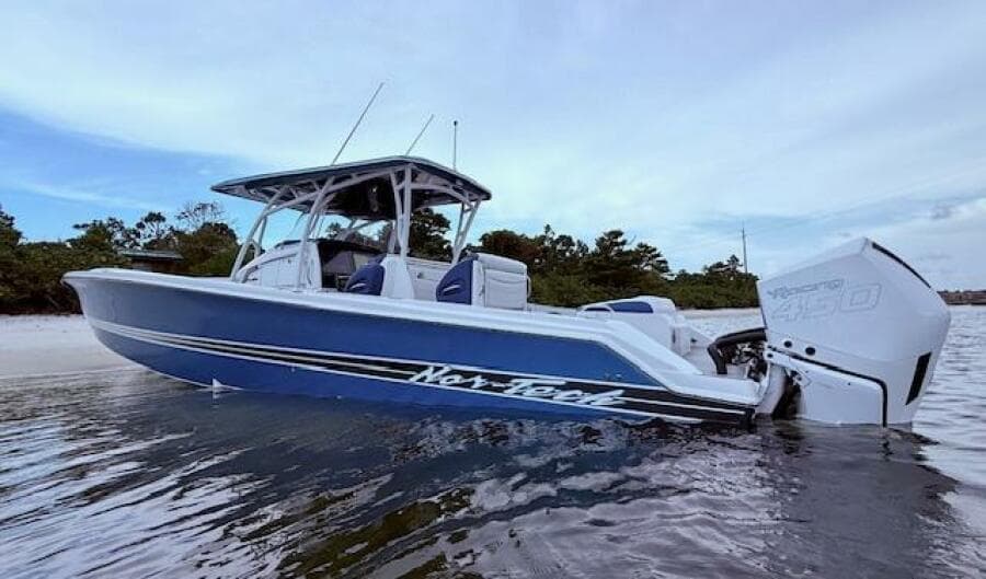 2022 Nor-Tech 390 Sport Center Console boat in water, side view, blue and white design.