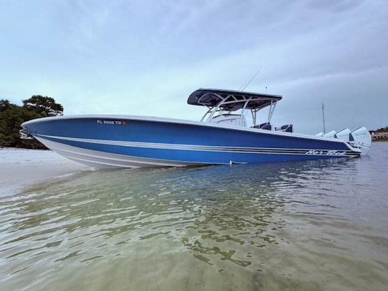 2022 Nor-Tech 390 Sport Center Console boat in shallow water, showcasing sleek blue design.