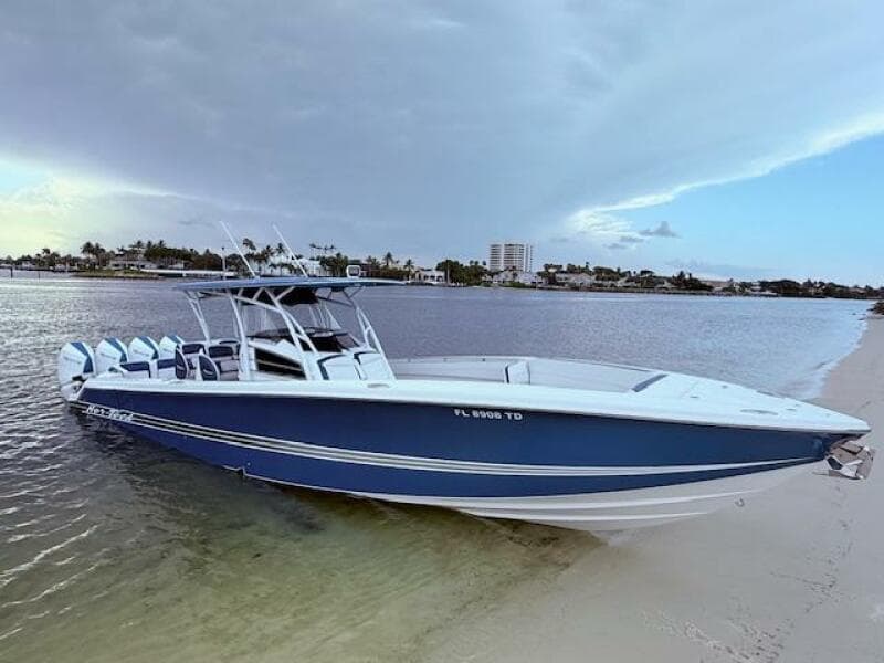 2022 Nor-Tech 390 Sport Center Console boat on sandy beach, calm water background.