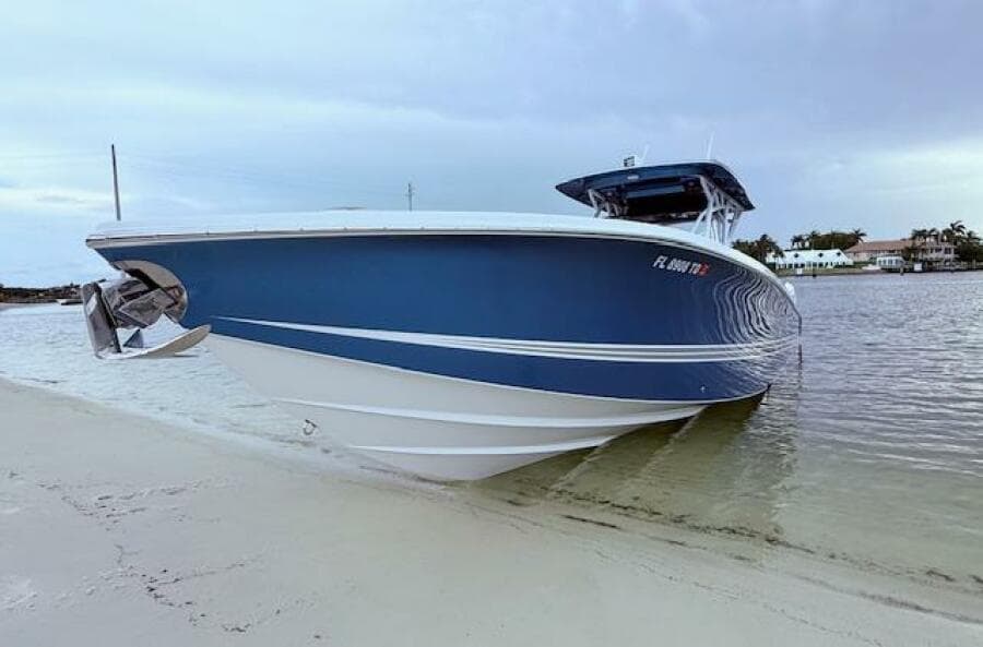 2022 Nor-Tech 390 Sport Center Console boat beached on sandy shore.