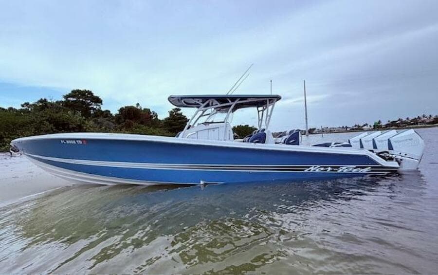 2022 Nor-Tech 390 Sport Center Console boat in shallow water, featuring a sleek blue design.