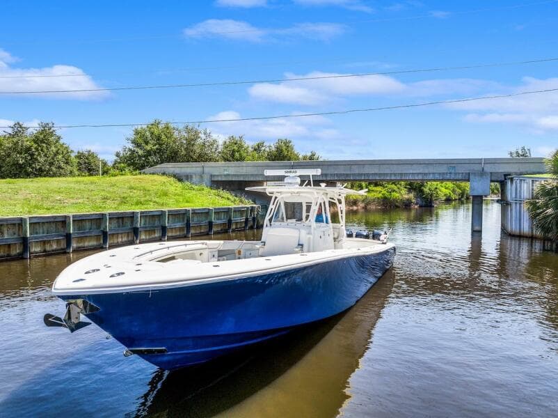 2015 Yellowfin 39 boat cruising on a calm river under a blue sky.