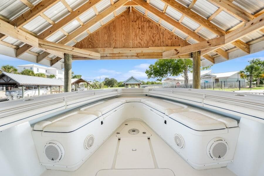 2015 Yellowfin 39 boat interior under wooden canopy, featuring cushioned seating and speakers.