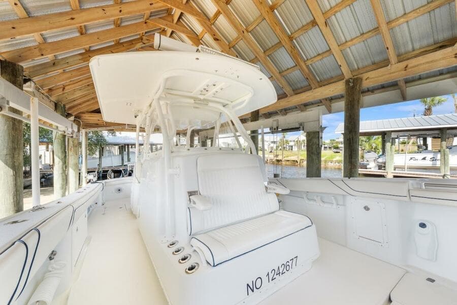 2015 Yellowfin 39 boat docked under wooden shelter, featuring spacious seating and sleek design.