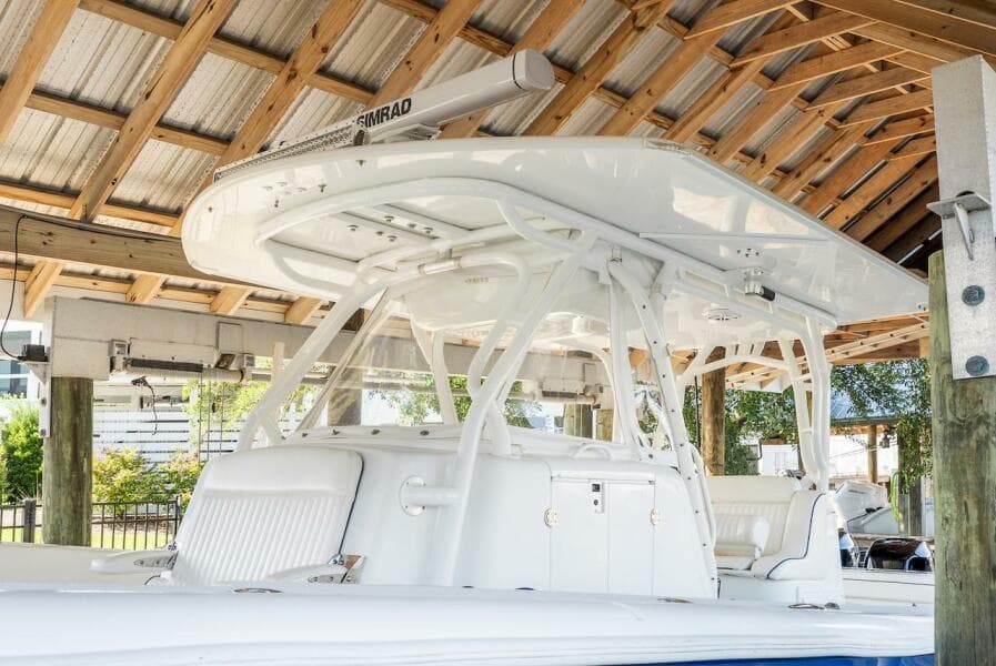 2015 Yellowfin 39 boat under wooden shelter, featuring sleek white design and advanced equipment.