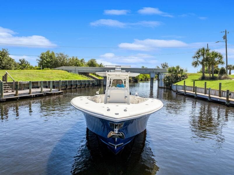 2015 Yellowfin 39 boat navigating a calm canal under a clear blue sky.