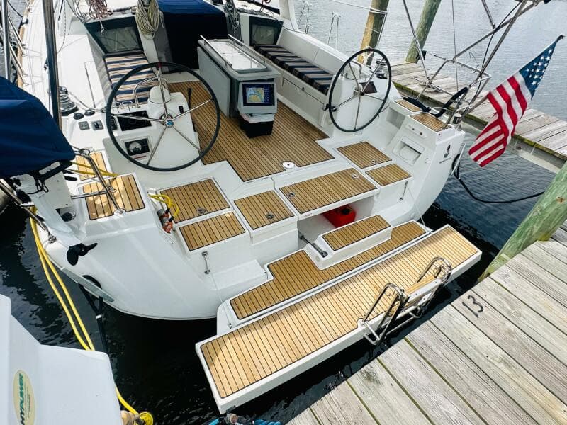 2015 Beneteau Oceanis 45 sailboat with dual steering wheels, docked with American flag.