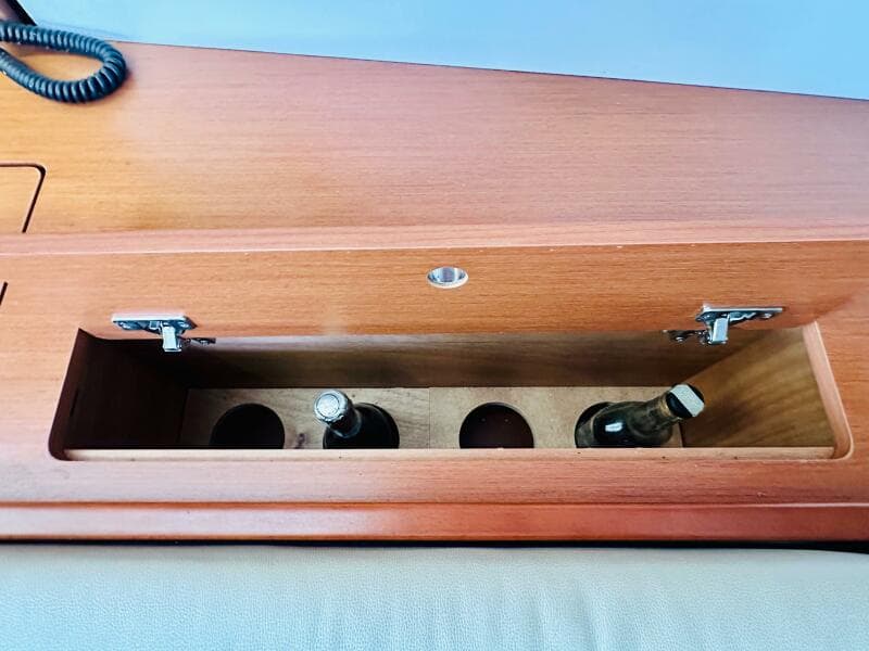 Wooden storage compartment with bottles on a 2015 Beneteau Oceanis 45 yacht.