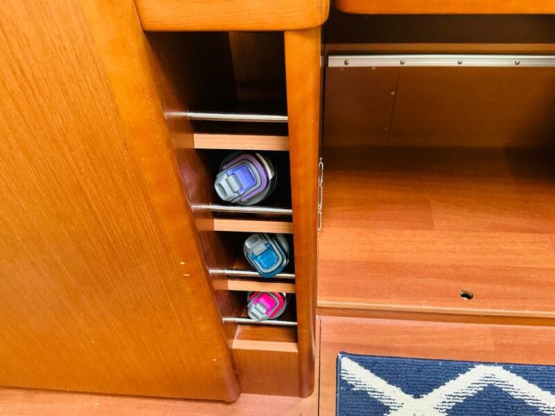 Wooden interior storage with water bottles on a 2015 Beneteau Oceanis 45 yacht.