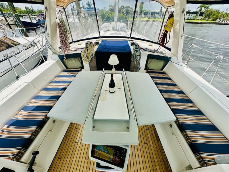 Cockpit of 2015 Beneteau Oceanis 45 with striped seating and table setup.