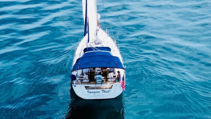 Beneteau Oceanis 45 sailboat on calm blue water, aerial view, 2015 model.