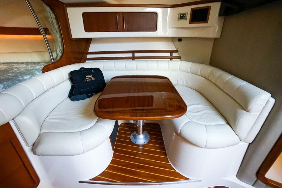2007 Grady-White Express 360 interior with white leather seating and wooden table.