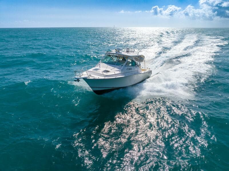 2007 Grady-White Express 360 cruising on open ocean under clear blue sky.