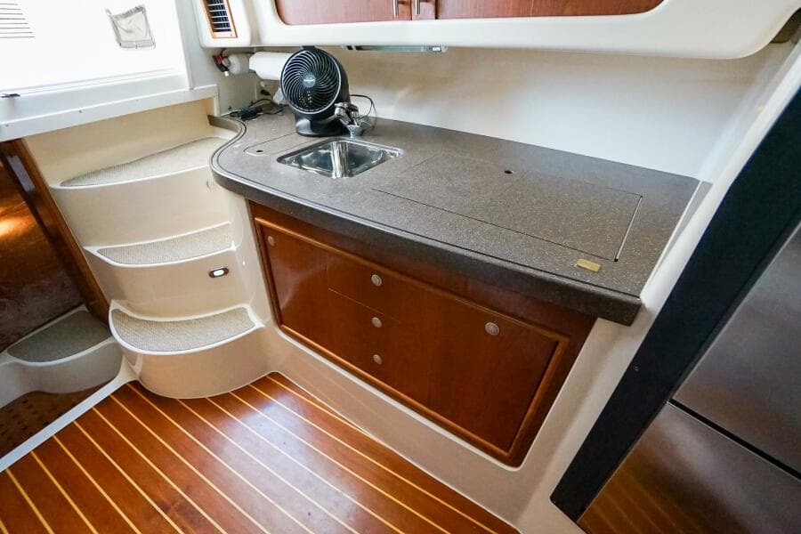 2007 Grady-White Express 360 interior with kitchenette, sink, and wooden flooring.