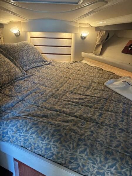 Cozy cabin interior of 2007 Monterey 350 Sport Yacht with patterned bedding and soft lighting.