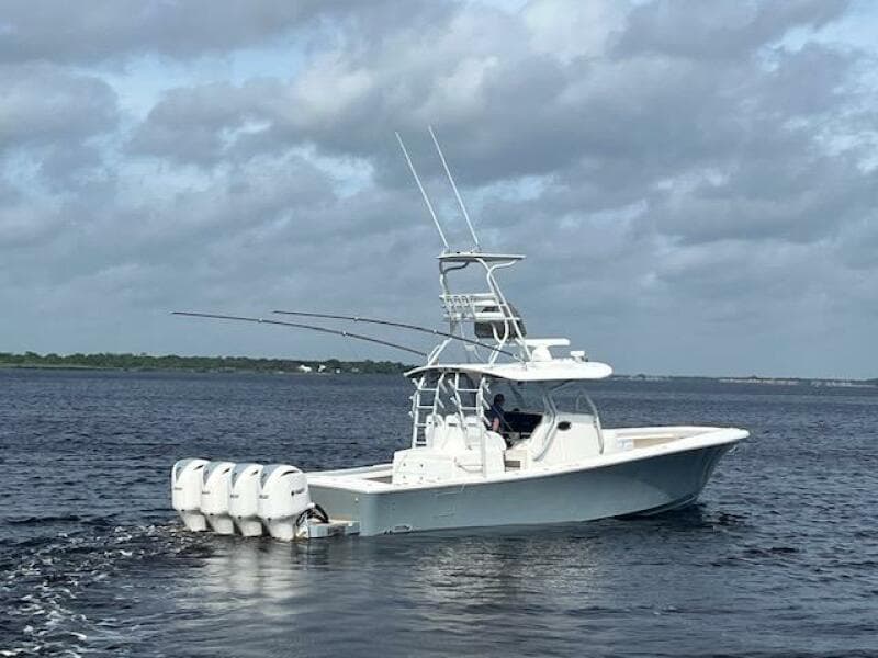 2018 Regulator 41 boat with four engines cruising on open water under cloudy skies.
