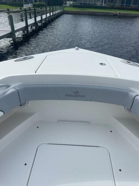 2018 Regulator 41 boat bow with seating, docked by a wooden pier.