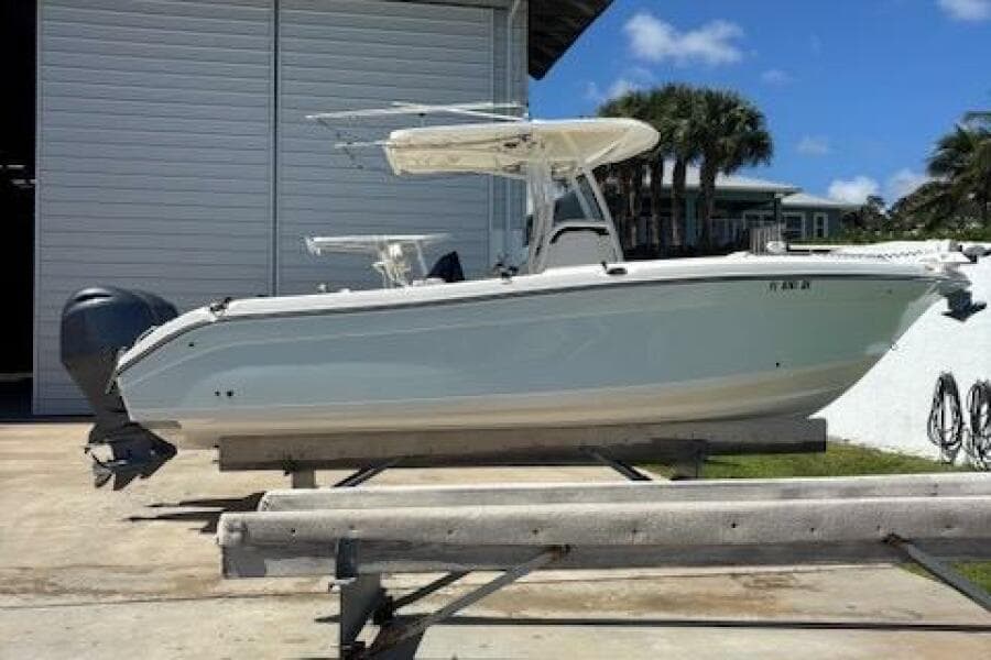 2018 Century 2600 Center Console boat on trailer, parked outdoors near a building.