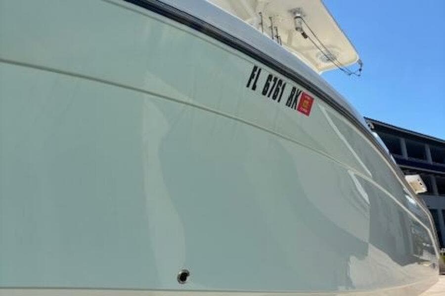 2018 Century 2600 Center Console boat with registration number, docked under clear blue sky.