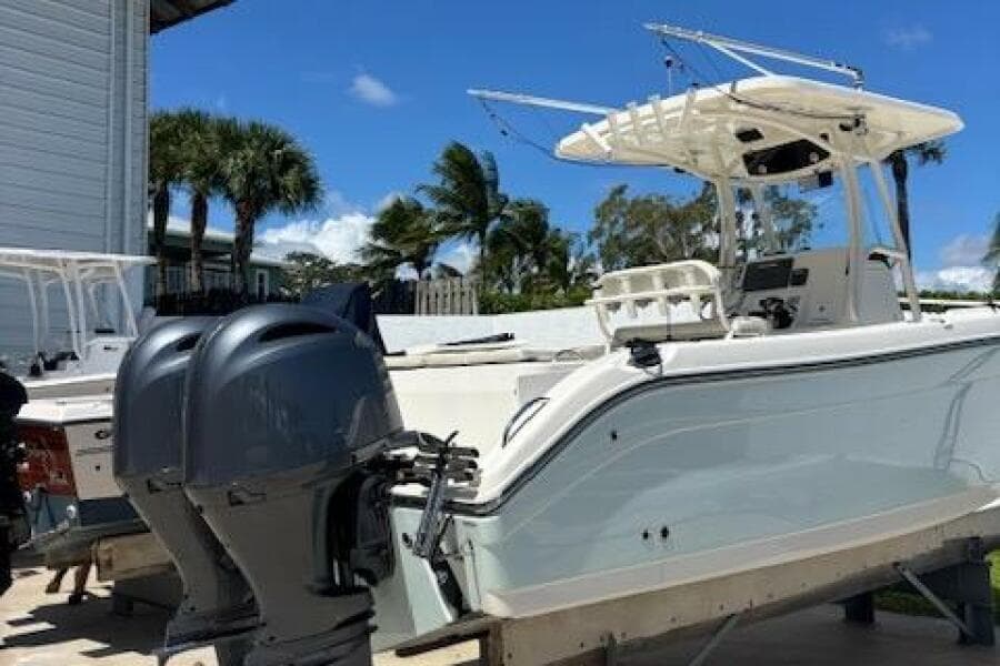 2018 Century 2600 Center Console boat with dual outboard motors, docked under a clear blue sky.