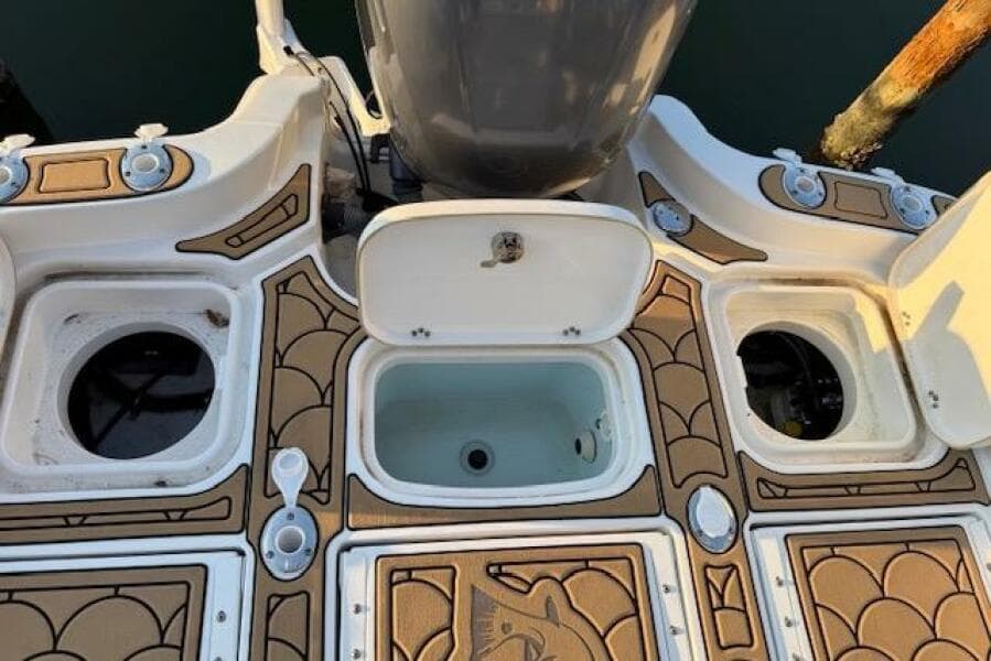 2018 Sea Hunt BX 25 FS boat deck with storage compartments and motor.