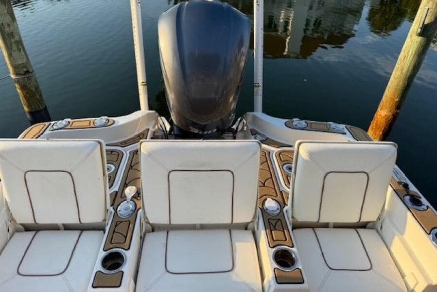2018 Sea Hunt BX 25 FS boat interior with seating and motor, docked on calm water.