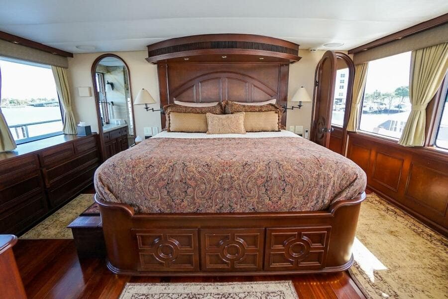 Luxurious bedroom interior on 1996 ABD 90 Explorer yacht with elegant wood finishes.