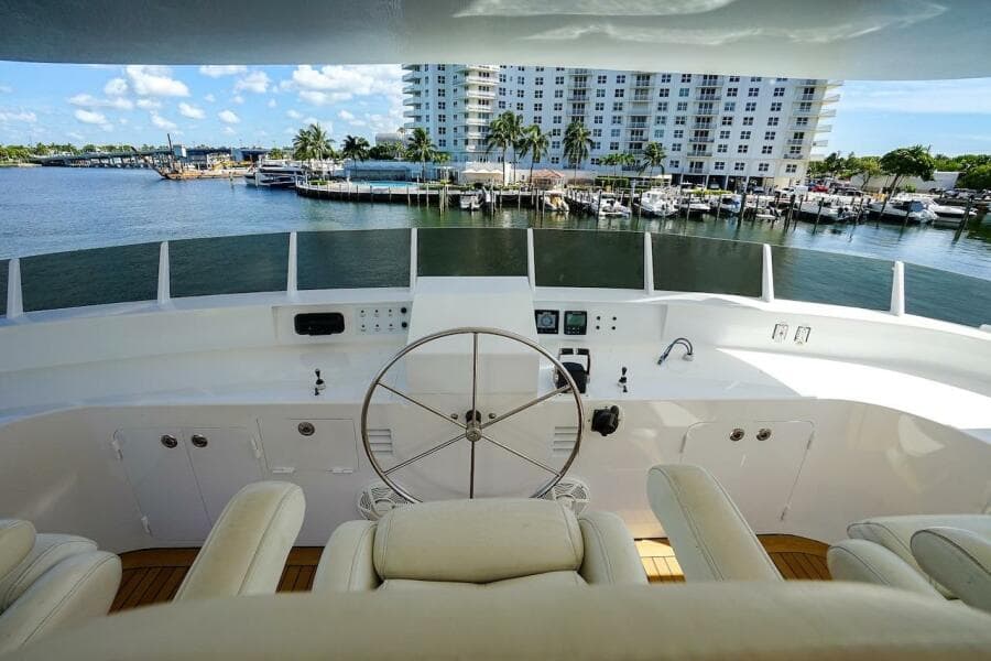 Luxurious yacht helm with white leather seats, overlooking a scenic waterfront. ABD 90 Explorer, 1996.