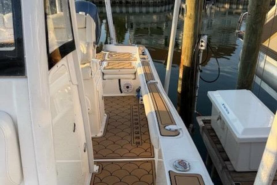 2018 Sea Hunt BX 25 FS boat docked, featuring a clean deck and stylish flooring.