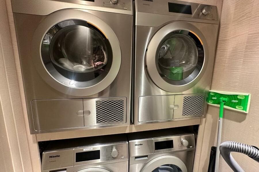 Stacked Miele laundry machines in a compact space, featuring a 2024 Majesty 120 model.